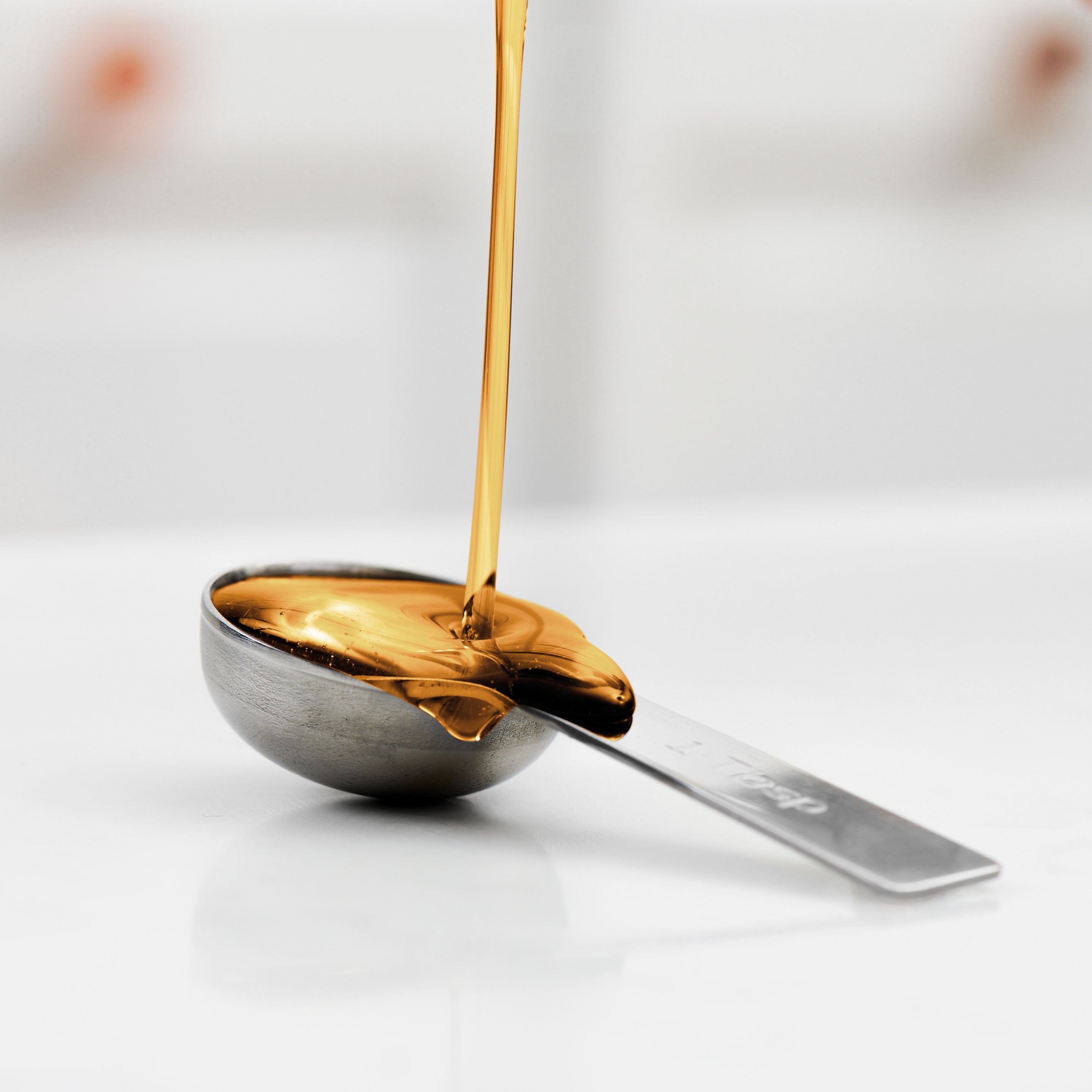 Vanilla syrup pours into spoon
